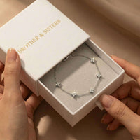 Thumbnail for Crystal Flower Bracelet by Brother & Sisters in a gift box, showcasing five sparkling crystal flowers on a delicate chain.
