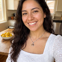 Thumbnail for Smiling woman with long dark hair in a white eyelet top in her kitchen, wearing the silver secret clover photo necklace | SKU: TPH-CLVN-SILVER