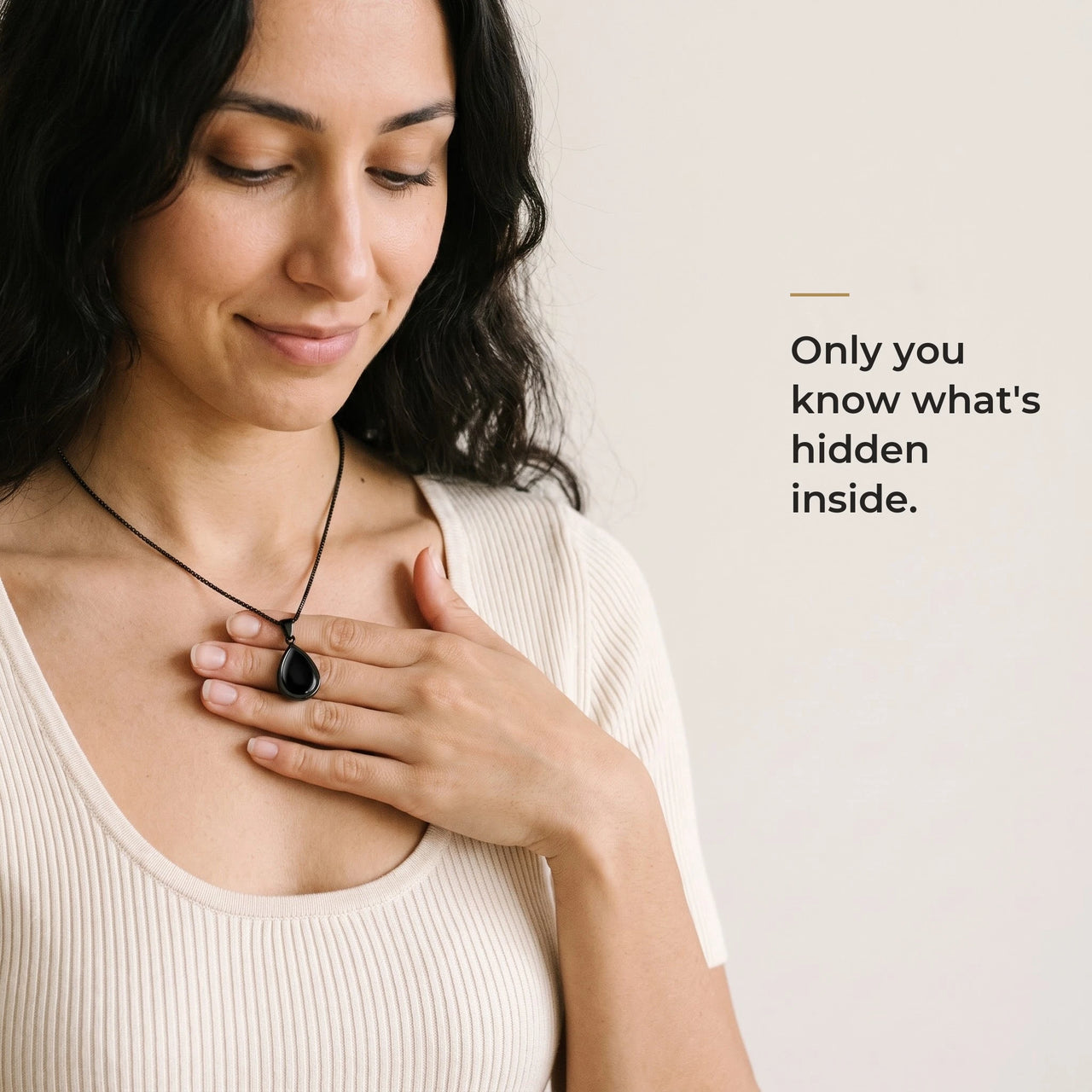 Woman holding the black teardrop pendant on its black chain against her chest, only she knows the photo inside | SKU: TPH-DRPN-BLACK