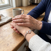 Thumbnail for Grandmother's hand on her granddaughter's, the silver heart photo bracelet on her wrist | SKU: TPH-HRTB-SILVER