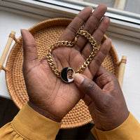 Thumbnail for Thumb warming the gold round bracelet plate: the hidden photo appears under the thumb while the rest stays black | SKU: TPH-RNDB-GOLD